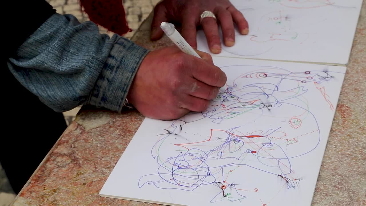 Detail shot of man's hands drawing in the center of Lisbon, Portugal.
