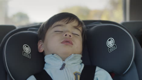 sleeping kid drive in the back seat of the car. asian baby sleeps in a child car seat