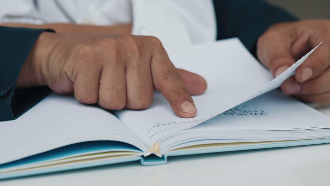 Primo piano di una mano che indica delle note su un quaderno