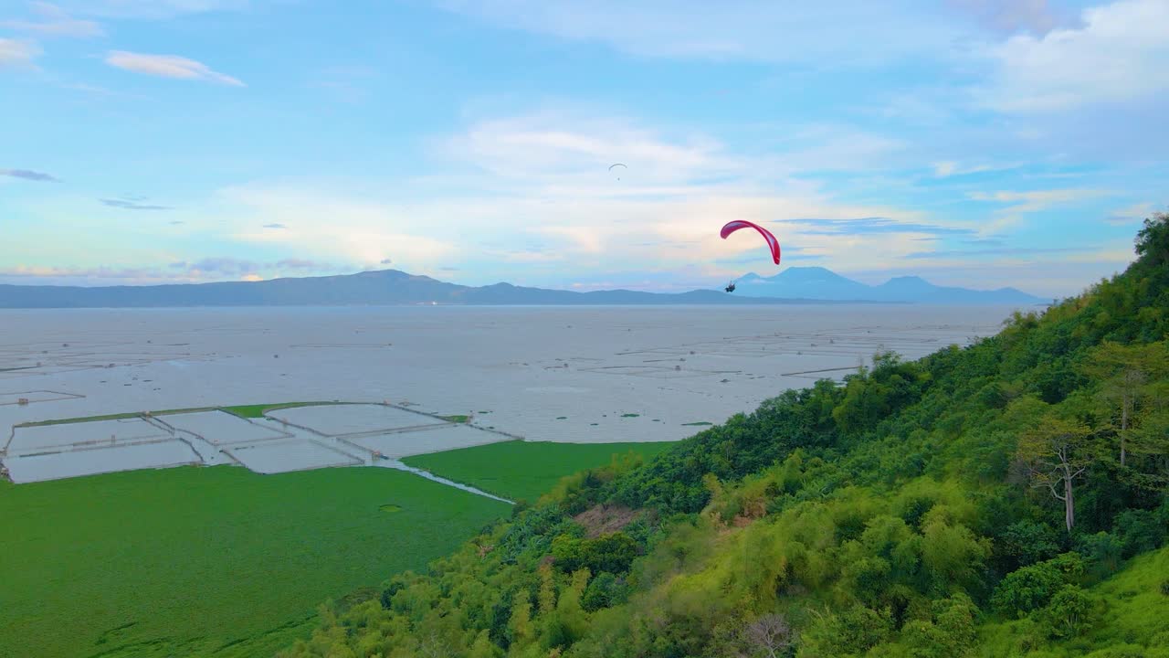 산 꼭대기에서 패러글라이딩 푸른 하늘 그린 필드 공중 촬영