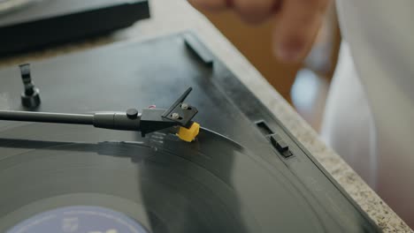 Mano-Ajustando-La-Aguja-En-Un-Tocadiscos-De-Vinilo,-Destacando-Un-Momento-De-Preparación-Musical