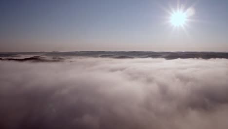 Antenne-über-Wolken-Und-Bergen-Mit-Der-Sonne-In-Der-Rechten-Ecke