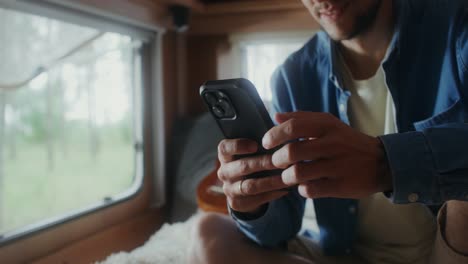 man using a phone in a camper van