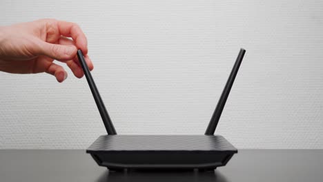 man folding out the antennas on a wifi router