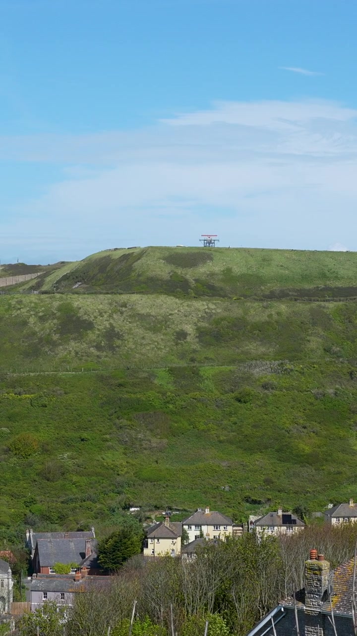 Un'inquadratura cinematografica verticale delle lussureggianti colline verdi e delle case residenziali a Weymouth e Portland, Dorset. Adatta per vlog di viaggio e contenuti di turismo regionale