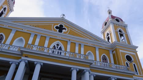 Pan-across-bright-yellow-facade-of-Granada-Cathedral-in-Nicaragua