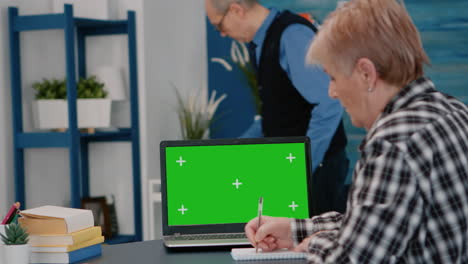 persona de edad avanzada leyendo en la pantalla verde, maquillaje, pantalla de tecla de croma de la computadora portátil