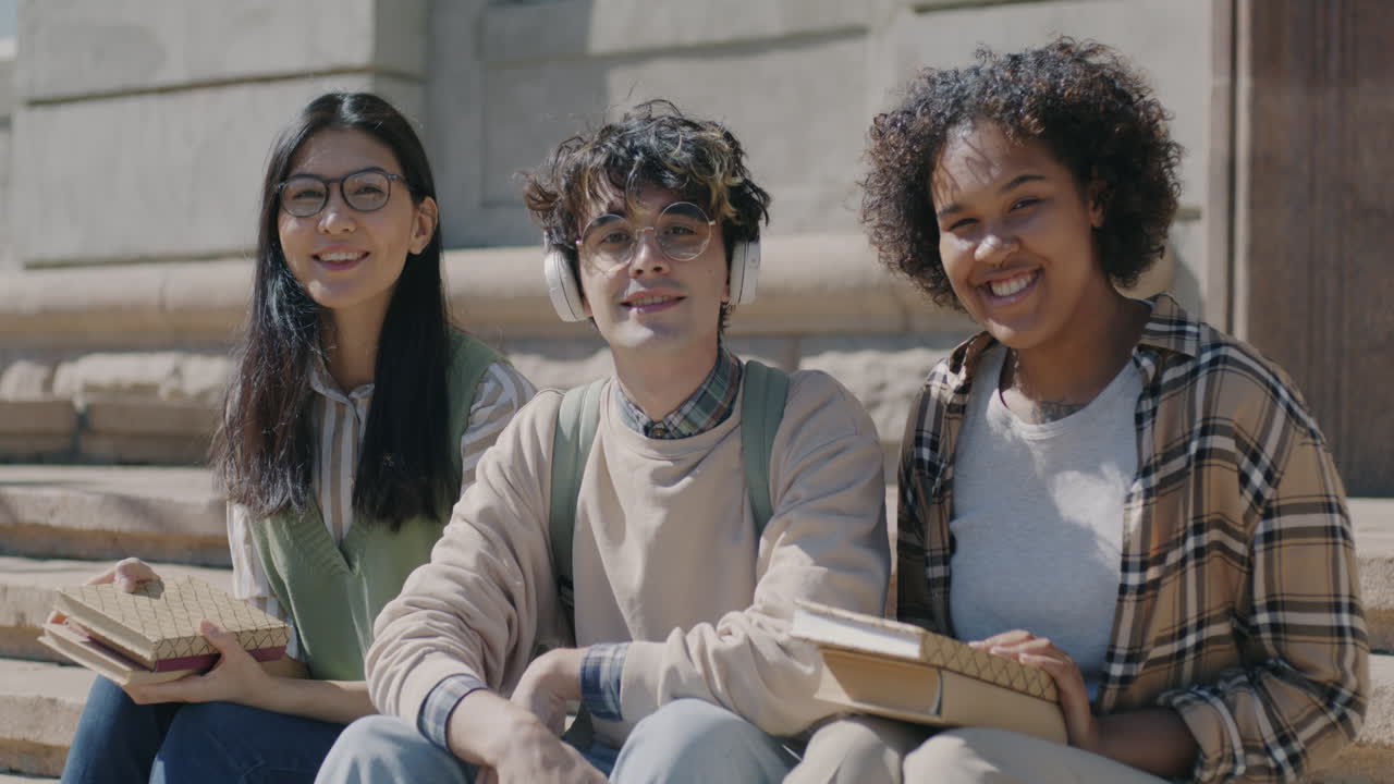Three Students Sitting on Campus Stairs