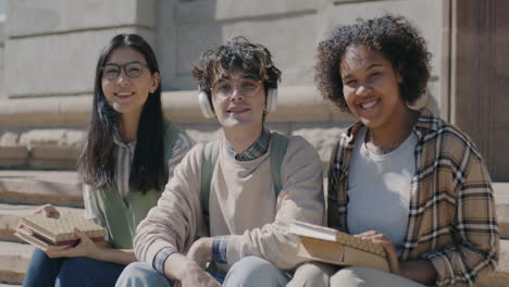 three students sitting on campus stairs