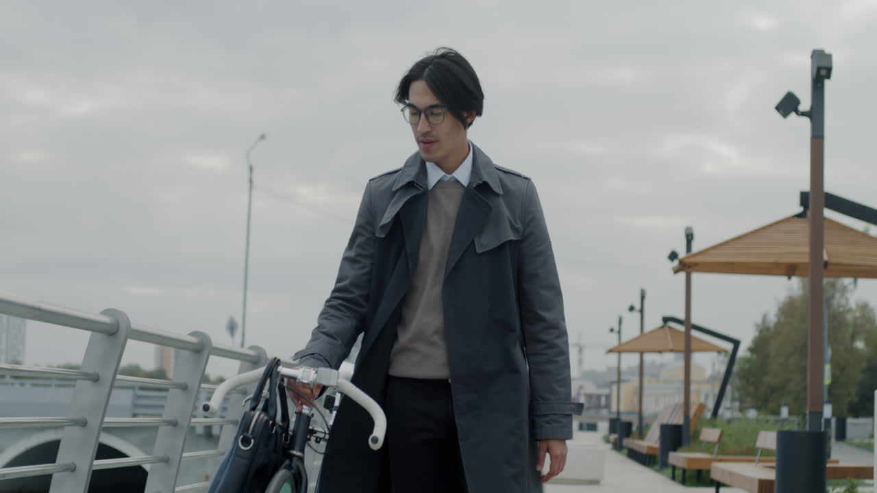 Man walking with a bike in a city park