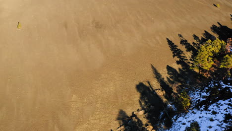 Aerial-rising-view-over-steep-dry-sandy-volcanic-cinder-cone-lava-mountain-of-Sunset-Crater