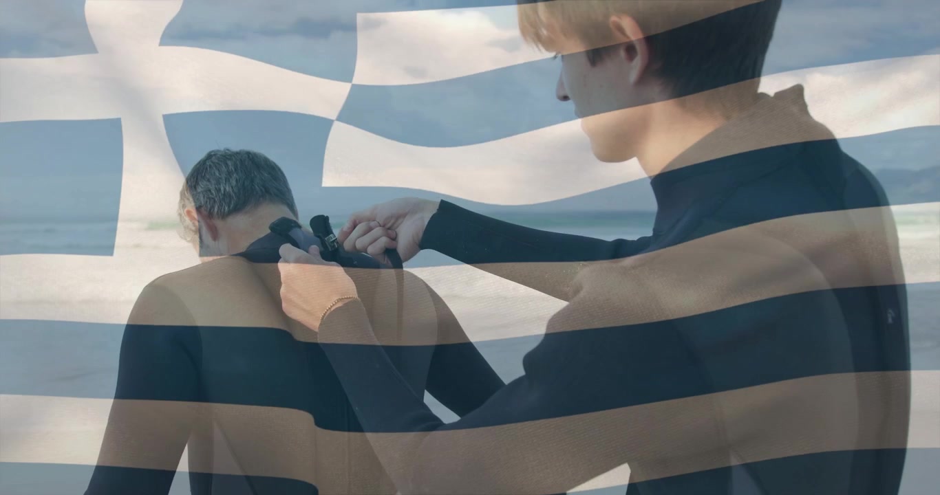 Assistent lyner brugerens våddragt på stranden, forbereder sig på at surfe, med flag-overlay.