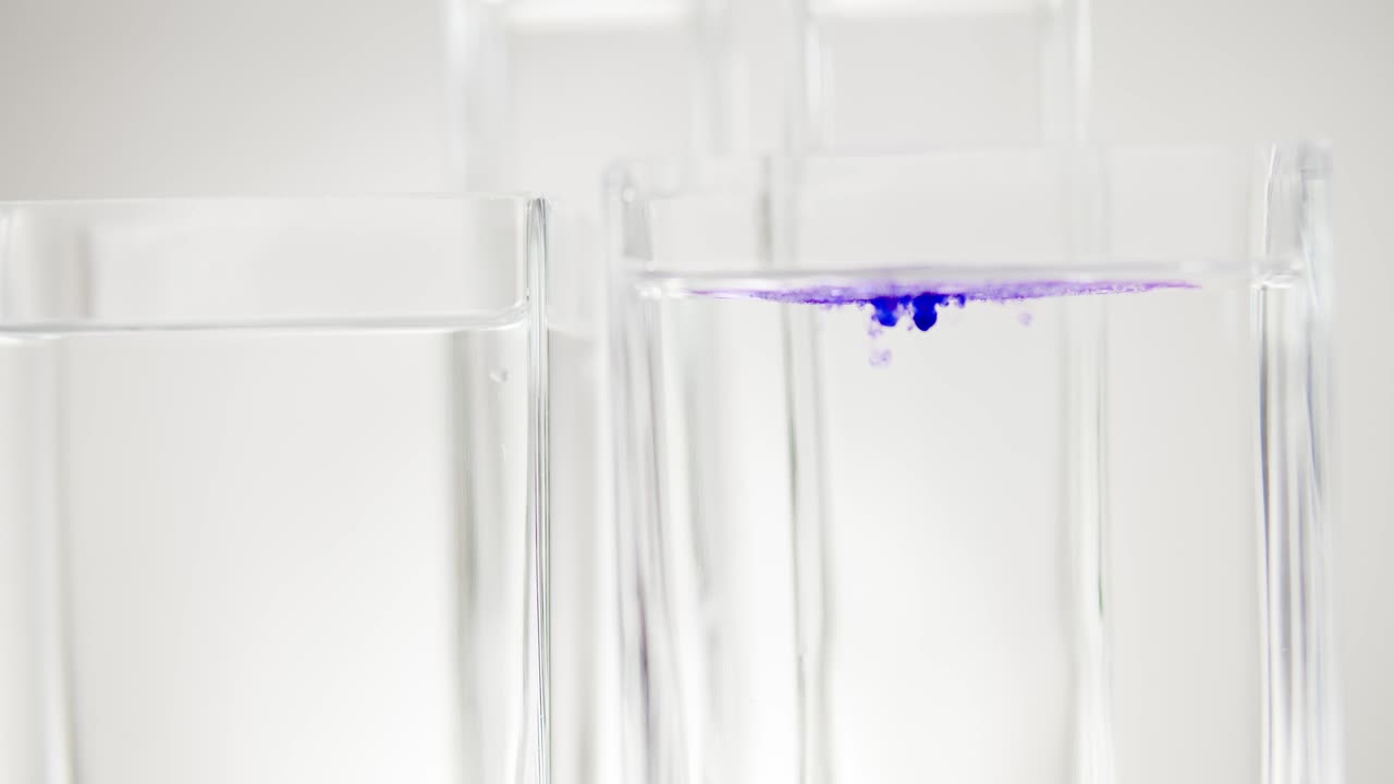 gota de tinte de color en un recipiente de vidrio con agua