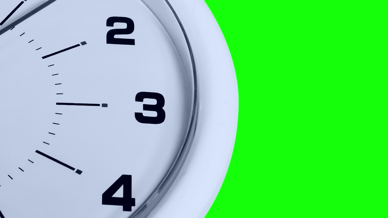 Primo piano di un orologio bianco con numeri e una lancetta che ticchetta, ripreso con sfondo green screen.