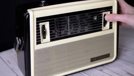 un dedo femenino sintonizando la frecuencia en un viejo receptor analógico vintage. 4k