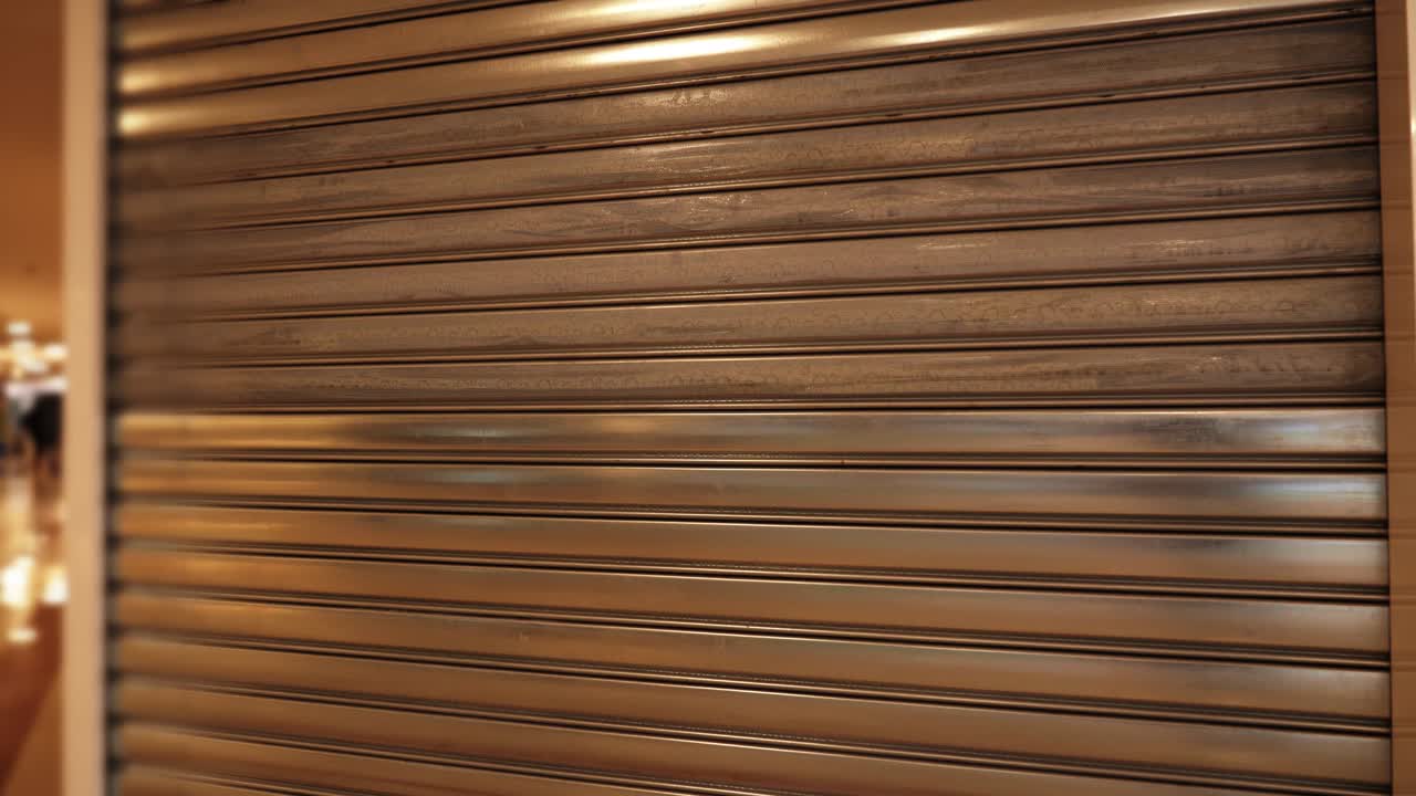 Motion to large store closed with metal shutters in mall