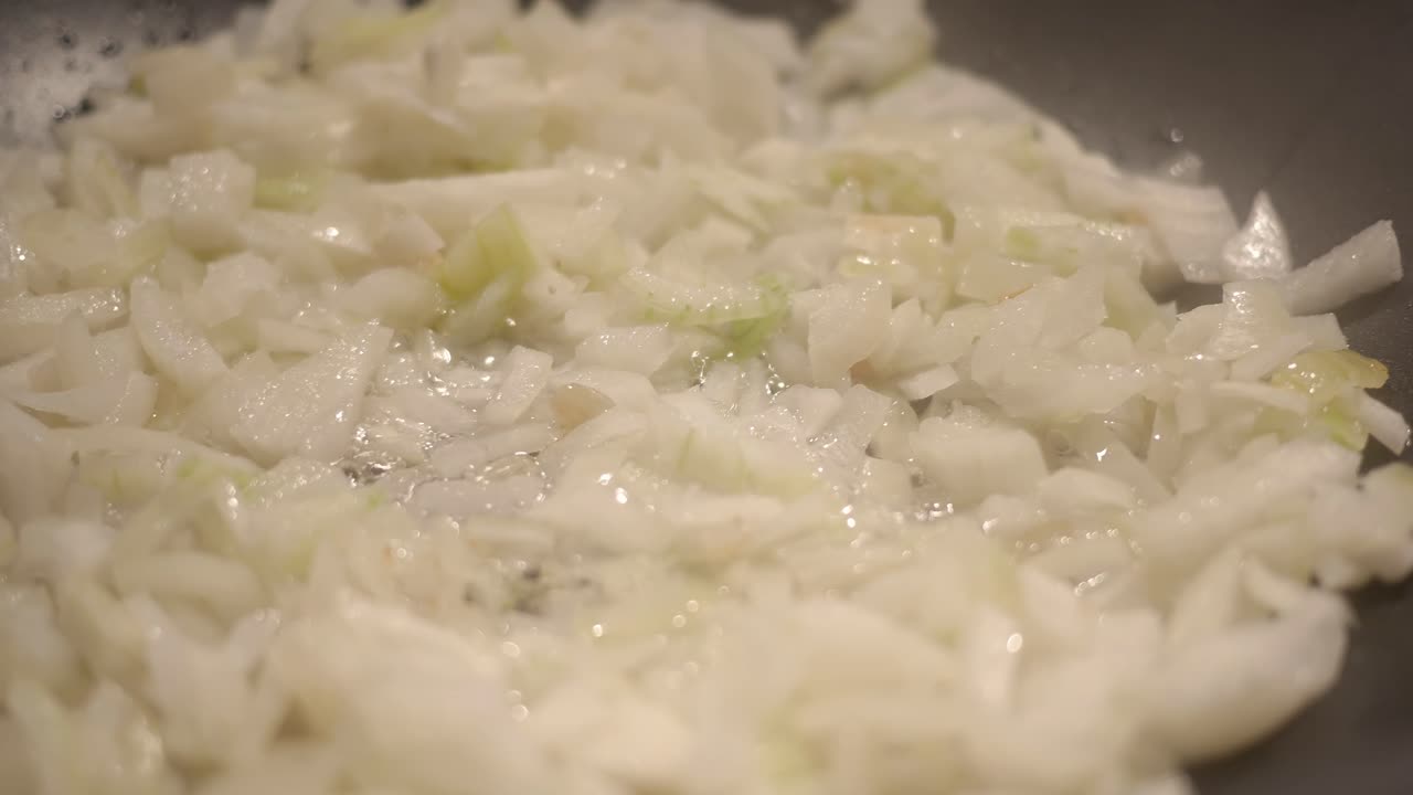 팬에 기름에 튀긴 잘게 썬 양파의 클로즈업 샷