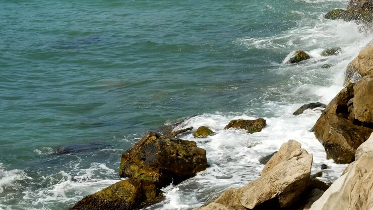 Onde che si infrangono sugli scogli sulla spiaggia in Montenegro.