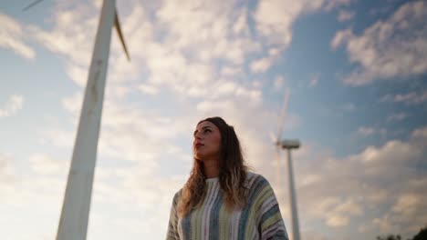 woman contemplating wind turbines: a symbol of clean energy