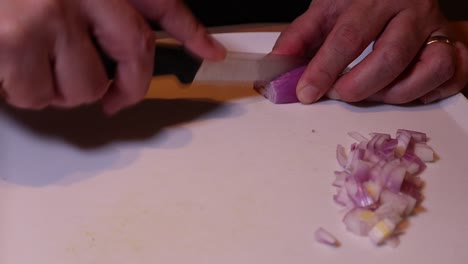 cutting onion with a knife on wooden table