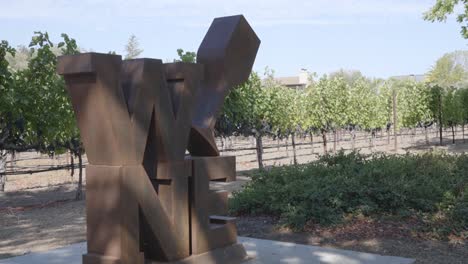 a static shot of a sculpture in napa valley yountville in front of a vineyard