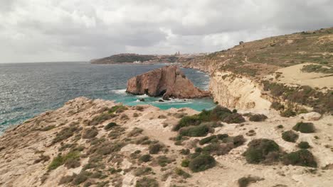 Un-Dron-Orbita-Una-Enorme-Roca-En-El-Mar-De-Gozo,-Cerca-De-La-Costa