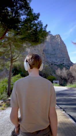 man walking outdoors in nature with headphones