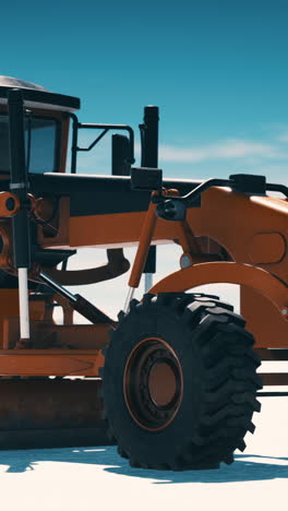 orange grader on a construction site