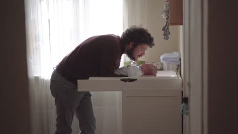 father interacting with newborn baby at home