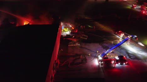 side view of polymer plant factory as fire fighters respond to inferno