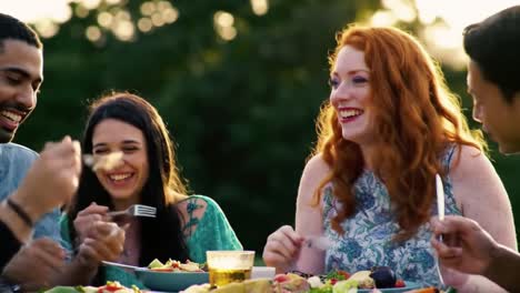 joyful gathering: friends sharing laughter and delicious food in a sunlit outdoor celebration, highlighting the essence of connection and togetherness