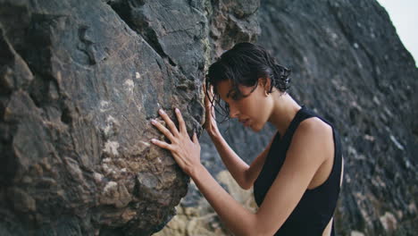 glamorous girl posing rocks at cloudy shore closeup. stylish fashion model touch