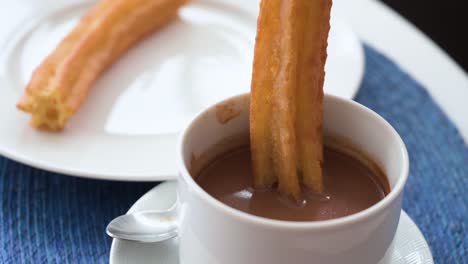 a slow-motion footage stiring spanish churros in hot chocolate dip