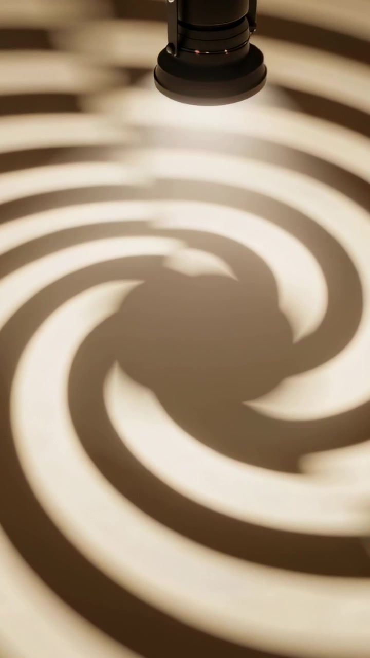 Vertical video: Motor starting, projector casting spiraling warm rings on ceiling, revealing gobo