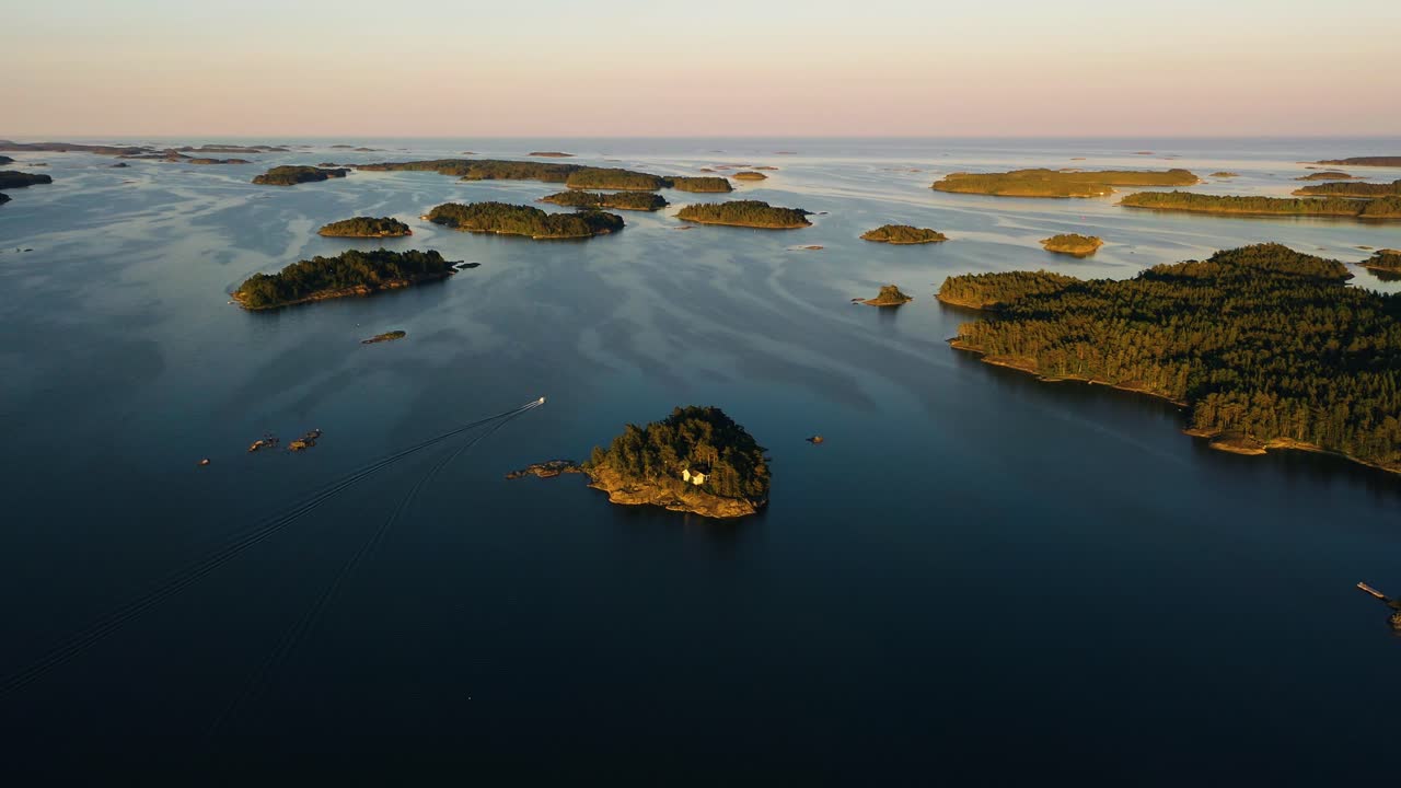 Vista aérea desde lo alto alrededor de un barco, navegando entre islas, tranquilo, tarde de verano, en el golfo de Finlandia, en el archipiélago finlandés: órbita, toma con dron