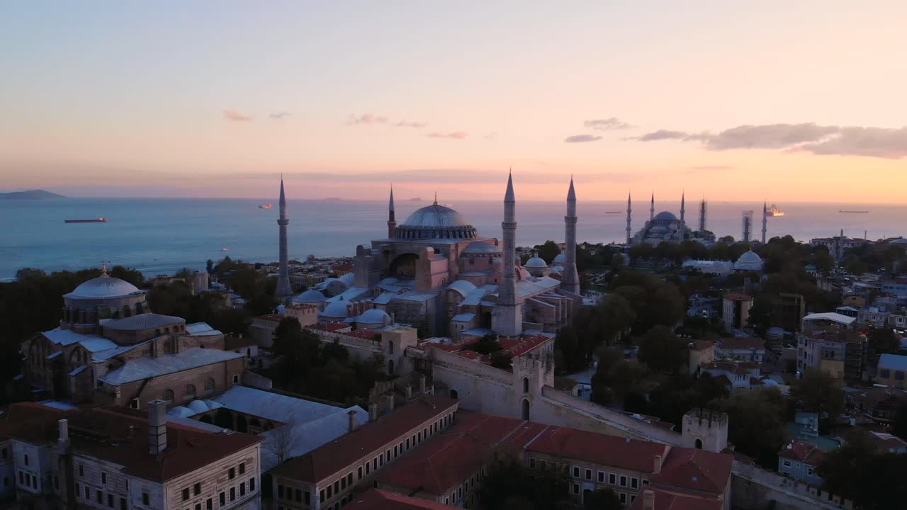 gran mezquita hagia sophia durante la puesta de sol de la hora dorada en estambul, turquía, con la icónica mezquita azul en el fondo - retirada de drones