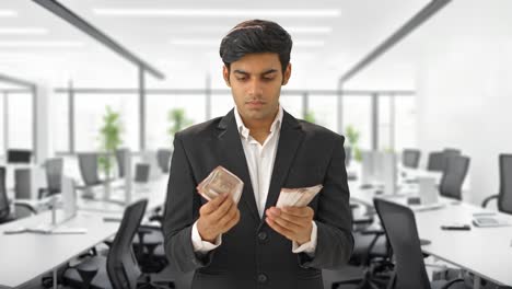 Indian-manager-counting-money-in-office