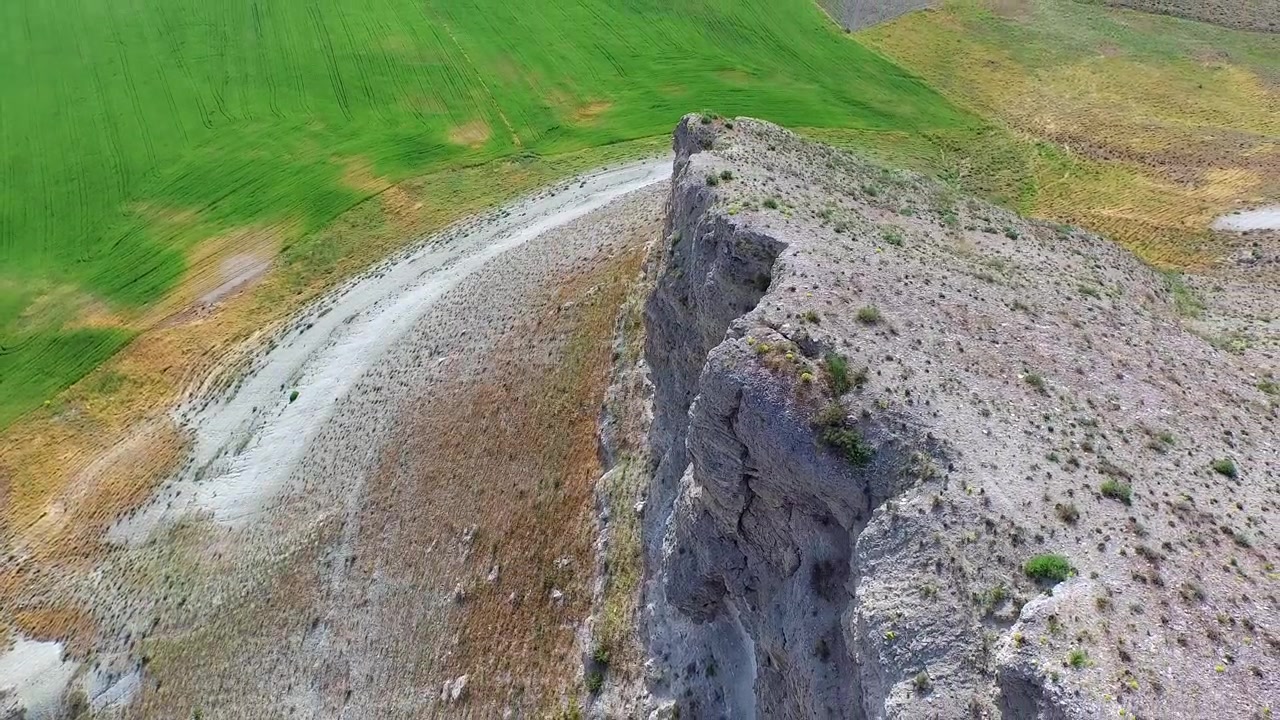 Letecký pohled na skalnatý útes s výhledem na zelená pole