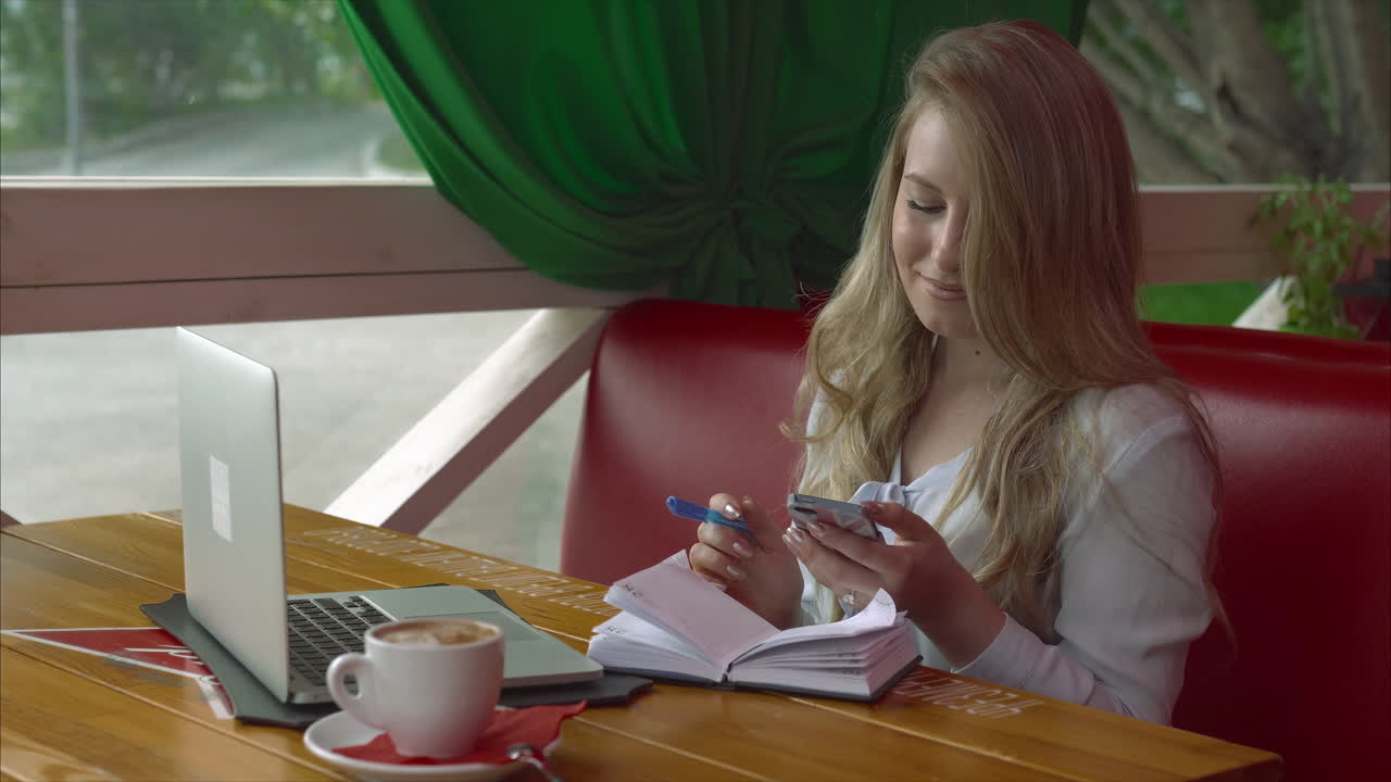 Una mujer joven trabajando en un café.