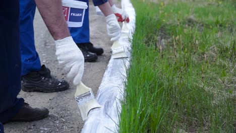 workers painting road curb