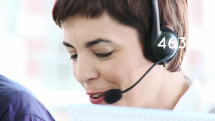 Animasjon av tall som endrer seg over en forretningskvinne som bruker telefonhodesett