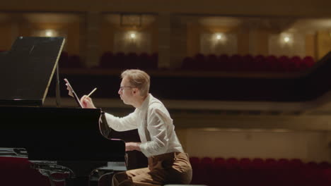 composer writing piano sheet music and throwing paper away