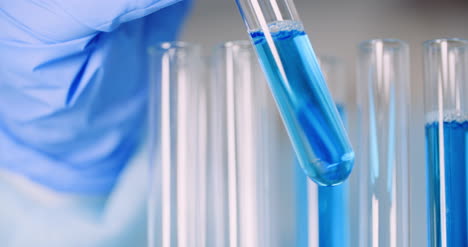 Working-In-Lab-Scientist-Holding-Test-Tubes-And-Analyzing-Liquid-2