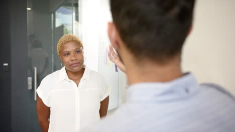 collaborating on project details, multiracial colleagues discussing in modern office environment