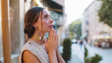retrato de una mujer orando con los ojos cerrados a dios pidiendo bendición ayuda perdón al aire libre