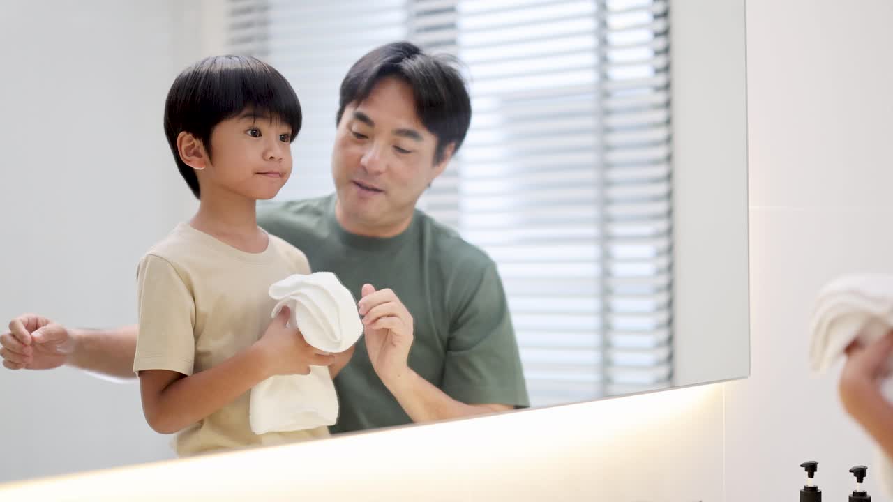 A father and son share a joyful morning routine in a bright bathroom, emphasizing bonding and daily hygiene