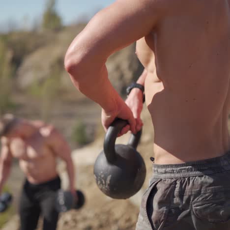 . active sportsmen training outdoor. muscular sportsman training outdoors with dumbbell