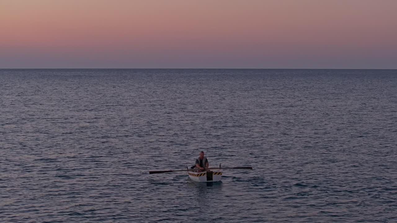 Aerial view of small boat cutting through calm dawn waters in Kizkalesi