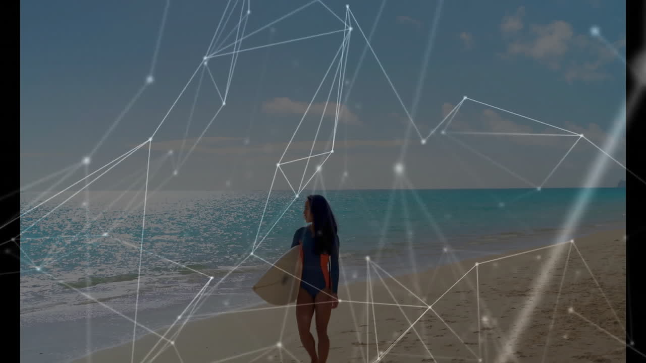 Standing on beach, surfer with digital network animation overlaying scene