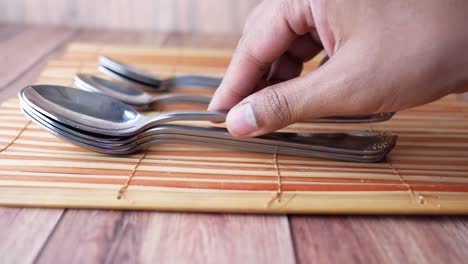 cucharas apiladas en placemat de bambú